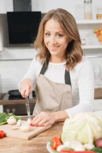 Seraphina, founder of Zero to Yum Recipes, smiling in her kitchen while preparing a healthy weight loss meal"