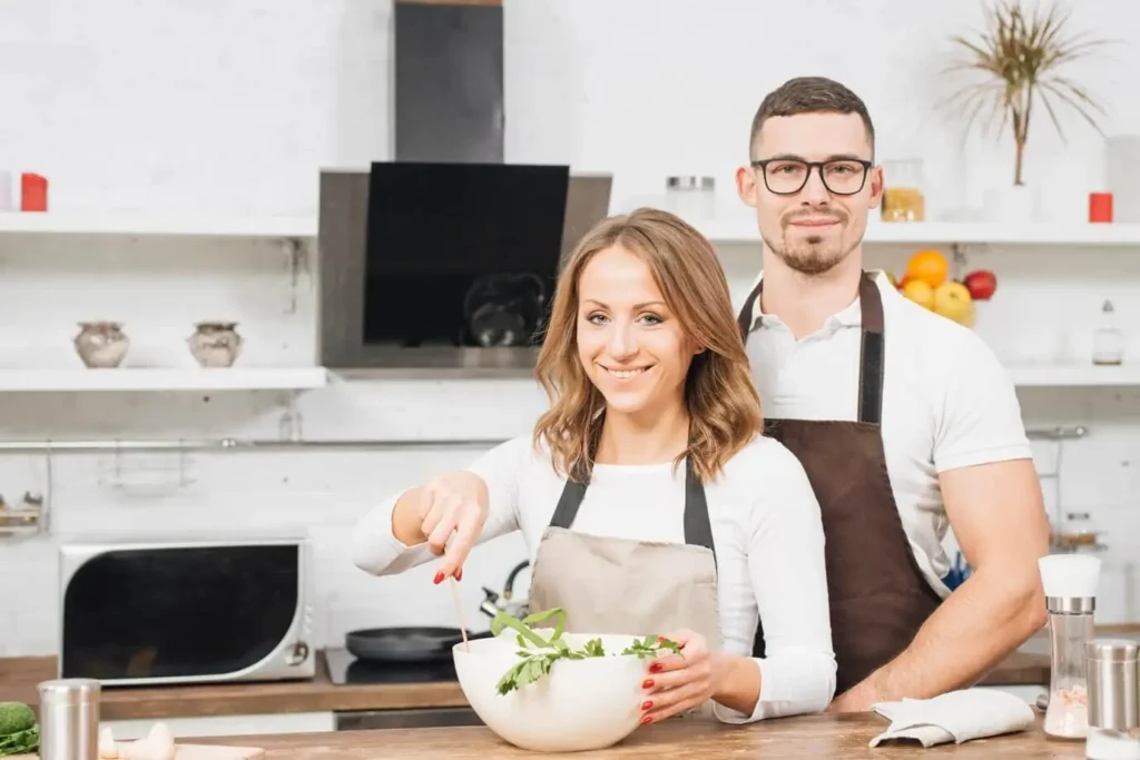 Seraphina and her husband Peter smiling together in their kitchen while preparing a healthy weight loss meal